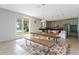 Bright dining area featuring wood table, stainless steel accents, and a colorful rug, adjacent to the modern kitchen at 8231 Chilton Dr, Orlando, FL 32836