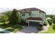 An eye-level view of a two-story home with a paver driveway and manicured landscaping at 8231 Chilton Dr, Orlando, FL 32836