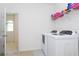 Bright laundry room featuring white washer and dryer, and convenient shelving at 8231 Chilton Dr, Orlando, FL 32836