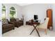 Bright home office with white walls, arched window and comfortable seating area at 8231 Chilton Dr, Orlando, FL 32836