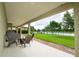 Covered patio includes seating around a fire pit with a peaceful view of the well-manicured backyard and lake at 8231 Chilton Dr, Orlando, FL 32836