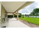 Covered patio overlooking a well-manicured lawn, lake, and fountain, perfect for outdoor entertaining at 8231 Chilton Dr, Orlando, FL 32836