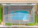 Overhead view of a screened in pool and spa featuring brick pavers surrounded by landscaping at 9026 Rhodes St, Kissimmee, FL 34747