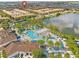 Gorgeous aerial view of the community pool, spa, and lake, showcasing the outdoor amenities and lush landscaping at 9026 Rhodes St, Kissimmee, FL 34747