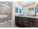Modern bathroom featuring a double vanity, granite countertops, and a glass-enclosed shower at 9026 Rhodes St, Kissimmee, FL 34747