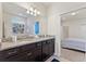 Elegant bathroom featuring a double vanity with granite countertop and dark wood cabinets at 9026 Rhodes St, Kissimmee, FL 34747