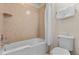 Bathroom with a bathtub, shower curtain, beige tile, and white towels at 9026 Rhodes St, Kissimmee, FL 34747