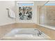 Relaxing bathtub with tiled surround, towel rack, and artwork for a serene bathing experience at 9026 Rhodes St, Kissimmee, FL 34747