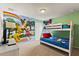 Charming bedroom with a bunk bed, colorful Mickey Mouse mural, and a view of the exterior at 9026 Rhodes St, Kissimmee, FL 34747