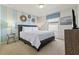 Bright bedroom featuring blue striped accent wall, modern decor, and a large window at 9026 Rhodes St, Kissimmee, FL 34747