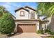 Two-story home featuring a brown tile roof, a brick driveway, and a two-car garage at 9026 Rhodes St, Kissimmee, FL 34747