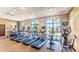 Bright gym features treadmills and fitness machines with views of the community and palms through large windows at 9026 Rhodes St, Kissimmee, FL 34747