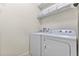Functional laundry room with a side-by-side washer and dryer and shelving for storage at 9026 Rhodes St, Kissimmee, FL 34747