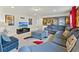 Spacious living room featuring a large gray sectional sofa, movie-themed decor, and a flat-screen television at 9026 Rhodes St, Kissimmee, FL 34747