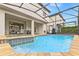 Screened outdoor pool and spa with a view of the covered patio and a spacious backyard at 9026 Rhodes St, Kissimmee, FL 34747