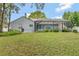 Large backyard with screened in porch and green grass at 10924 Dearden Cir, Orlando, FL 32817