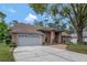 Brick home with a two car garage and concrete driveway at 10924 Dearden Cir, Orlando, FL 32817