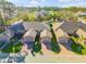 An aerial view shows the townhomes with brick driveways, garages, and manicured lawns at 114 Tuscany Villas Dr, Edgewater, FL 32141