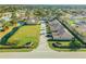An aerial shot shows townhomes near a tranquil pond and manicured green space in a quiet neighborhood at 114 Tuscany Villas Dr, Edgewater, FL 32141