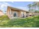 A home's backyard is showcased with green grass, sliding glass doors, and an AC unit at 114 Tuscany Villas Dr, Edgewater, FL 32141
