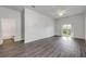Open living room with sliding glass doors to the backyard and wood-look floors at 114 Tuscany Villas Dr, Edgewater, FL 32141