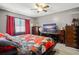 Bedroom features a comfortable bed with red and white patterned bedding, as well as matching red curtains at 1170 Calle Del Rey # D, Casselberry, FL 32707