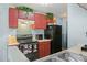 The kitchen features matching red cabinets and black appliances and a sink at 1170 Calle Del Rey # D, Casselberry, FL 32707