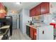Galley kitchen with stainless steel sink, black appliances, and gray flooring at 1170 Calle Del Rey # D, Casselberry, FL 32707