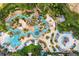 Aerial view of a resort community featuring winding lazy rivers and multiple pools surrounded by palm trees at 1432 Titian Ct, Reunion, FL 34747