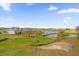 Aerial view of a golf course with a bridge over a lake and houses in the background at 1432 Titian Ct, Reunion, FL 34747
