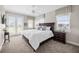 Well-lit bedroom features carpeted floors, white walls, ceiling fan, and double doors to the exterior at 1432 Titian Ct, Reunion, FL 34747
