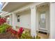 Inviting front porch featuring classic white columns, a stylish door, and colorful landscaping for curb appeal at 1432 Titian Ct, Reunion, FL 34747