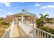 Covered gazebo on the upper level of the property, surrounded by tropical plants and trees at 1432 Titian Ct, Reunion, FL 34747