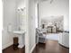 Open living space with hardwood floors, connecting the living room to the kitchen and a half bathroom at 1432 Titian Ct, Reunion, FL 34747