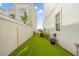 Side yard with artificial turf, offering a low-maintenance outdoor space between properties at 1432 Titian Ct, Reunion, FL 34747