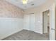 Cozy bedroom features patterned accent wall, modern wainscoting, and soft carpeting at 15489 Honeybell Dr, Winter Garden, FL 34787