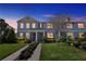 Charming two-story townhome with a well-maintained lawn and inviting front entrance at dusk at 15489 Honeybell Dr, Winter Garden, FL 34787