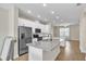 Stylish kitchen with white cabinetry, granite countertops, and a seamless flow into the living area at 15489 Honeybell Dr, Winter Garden, FL 34787