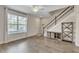 Welcoming living room featuring sleek floors, a large window, and convenient staircase access at 15489 Honeybell Dr, Winter Garden, FL 34787