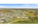 Expansive aerial view of a residential community surrounded by open fields and distant trees at 16413 Bloom Ct, Groveland, FL 34736