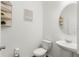 Cozy powder room featuring a pedestal sink, a round mirror, and decorative shelving at 16413 Bloom Ct, Groveland, FL 34736