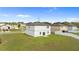 Exterior view of home with a well-maintained lawn, privacy fence, and an open backyard at 16413 Bloom Ct, Groveland, FL 34736
