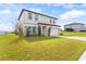 Exterior of a two-story home with a lush green lawn, complemented by young trees along the driveway at 16413 Bloom Ct, Groveland, FL 34736