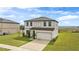 Exterior of a two-story home on a well-maintained lawn, showcasing the attached two-car garage at 16413 Bloom Ct, Groveland, FL 34736