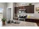 Modern kitchen featuring stainless steel appliances, granite countertops, and dark wood cabinets at 16413 Bloom Ct, Groveland, FL 34736