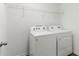 Well-equipped laundry room features a white washer and dryer and wire shelving for efficient organization at 16413 Bloom Ct, Groveland, FL 34736