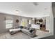Bright, open-concept living area with a view of the kitchen and a large sectional sofa at 16413 Bloom Ct, Groveland, FL 34736