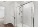 A modern shower with sleek glass enclosure, shelving and tiled surround adds a touch of elegance to the bathroom at 16413 Bloom Ct, Groveland, FL 34736