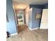 Hallway leading to bathroom with wood floors and blue walls at 1733 Weeping Elm Cir, Port Orange, FL 32128