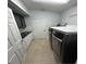 Well-lit laundry room featuring modern gray appliances and white cabinets for ample storage space at 1733 Weeping Elm Cir, Port Orange, FL 32128